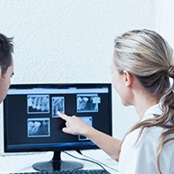Dentist and patient looking at dental X rays