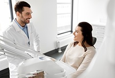 Patient and dentist smiling at each other in treatment room