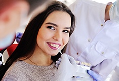 Woman smiling at dentist matching shade of teeth