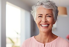Senior woman smiling in living room at home