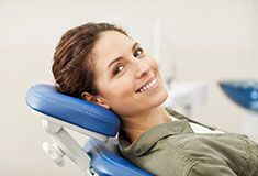 woman smiling while visiting emergency dentist in Forest