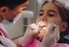 Closeup of dentist examining girl’s teeth