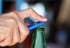 Man opening bottle with bottle opener