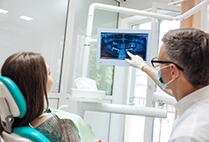 dentist explaining dental implant treatment in Forest to patient 