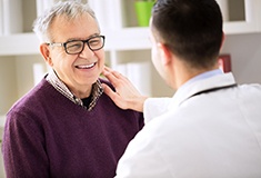 Patient learning more about dental implants in Forest from dentist 