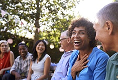 Diverse group of friends with dental implants in Forest laughing