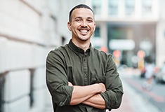 Man in green button up shirt smiling outside