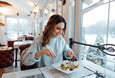 Smiling woman enjoying meal at restaurant