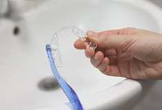 Patient cleaning clear aligner with toothbrush