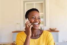 Woman smiling while talking on phone at home