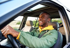Man smiles while driving