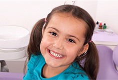 Smiling young girl in dental chair