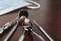 an extracted tooth on a table with dental tools