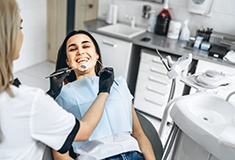 Dentist in Forest performing an oral cancer screening on a patient 