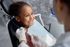 Child in Forest smiling after receiving dental sealants 