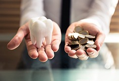 person holding tooth and coins