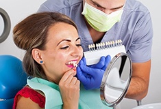 woman in red shirt trying on veneers in Forest 