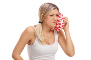 woman holding cold compress to her face
