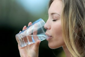Closeup of woman drinking fluoride in tap water