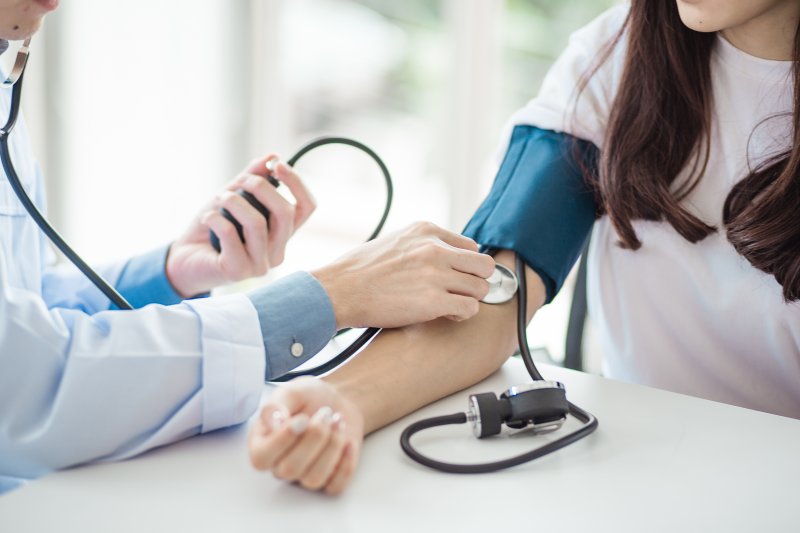 dentist measuring blood pressure during checkup