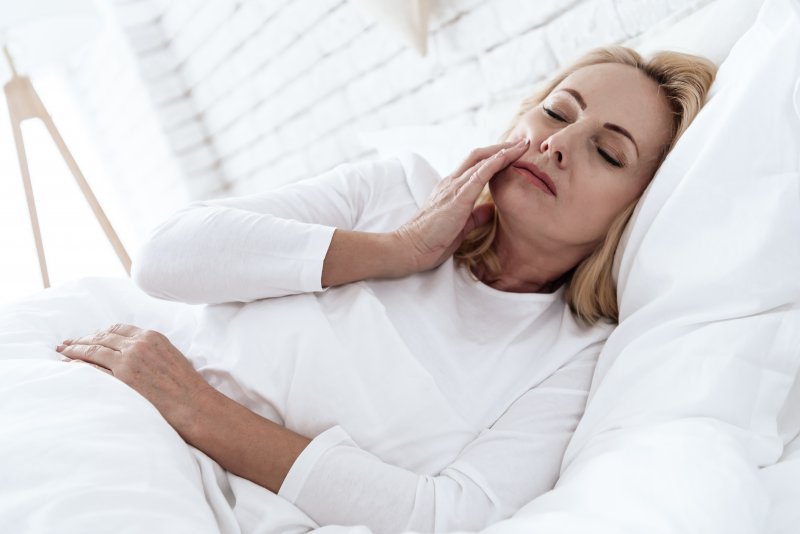 woman with toothache while in bed