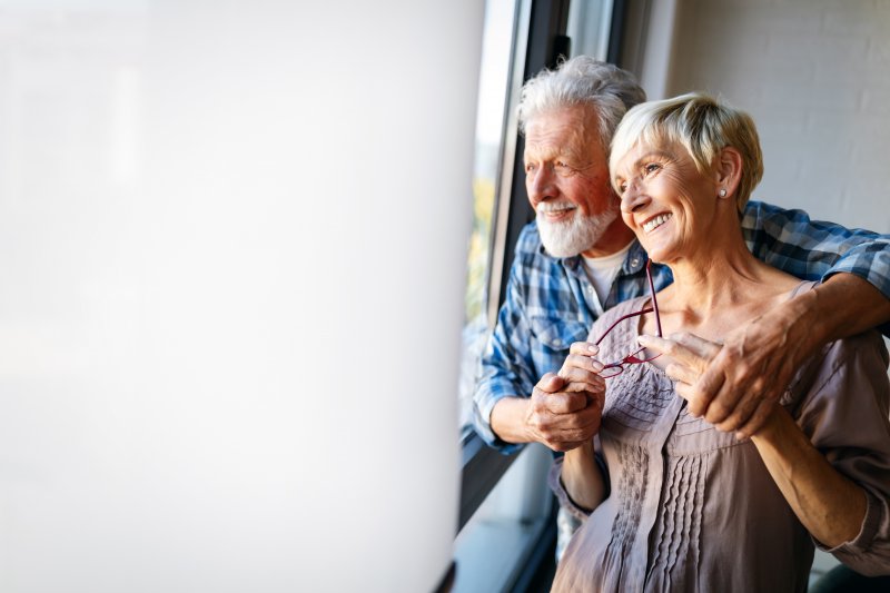 couple smiling with implant dentures