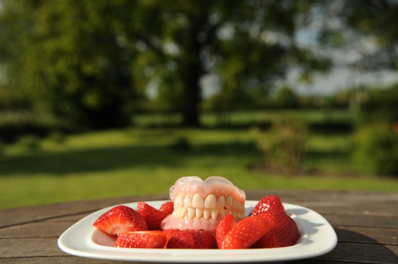 dentures surrounded by strawberries