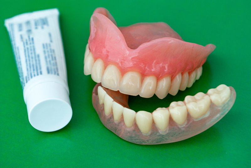 A pair of dentures and dental adhesive