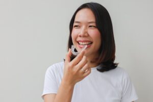 Woman smiling while putting in her retainer