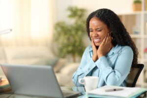 Woman holding face in pain.