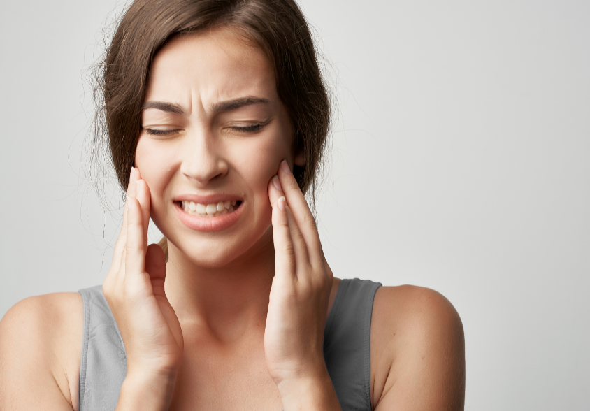 Woman holding jaw in pain