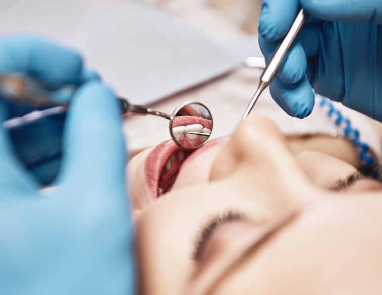 Dentist checking patient's mouth with mirrors